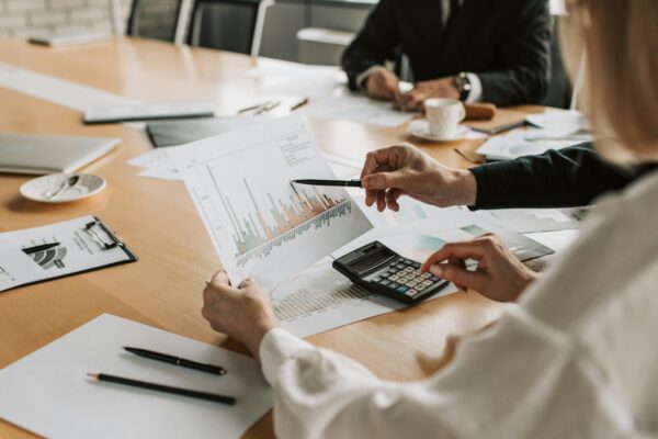 pexels-photo-7433837-7433837 Professionals reviewing financial graphs and charts during a meeting.