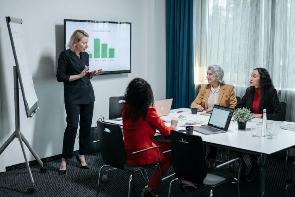 pexels-photo-8424459-8424459 A group of professional women engaged in a business presentation in a modern conference room.