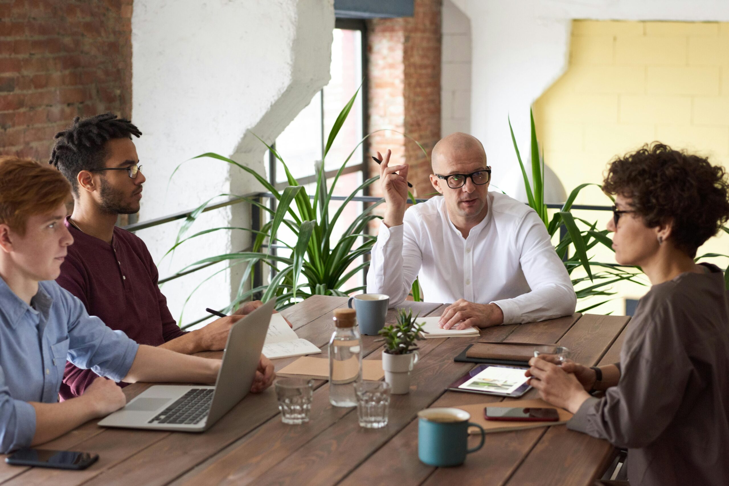 A group of colleagues in a modern office having a strategic discussion about Managing Public Procurement.