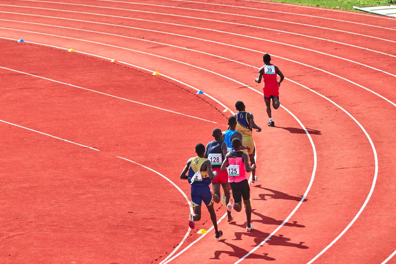 pexels-ansey-30144519 A group of athletes running on a curved outdoor track in a competitive race.
