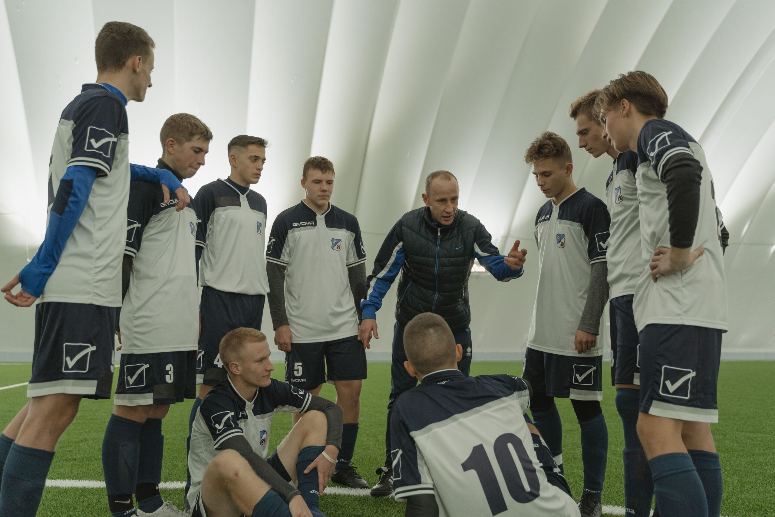 pexels-tima-miroshnichenko-6077808 A coach passionately instructs his soccer team during a practice session inside a sports dome.